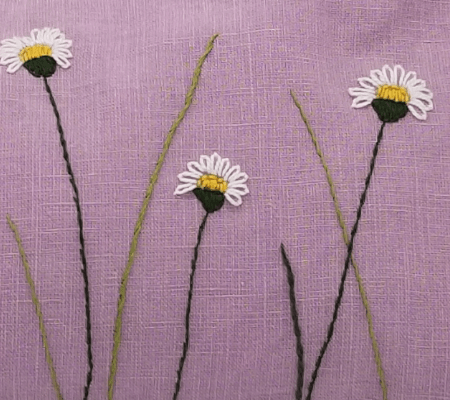 Dinkelspelzkissen Gänseblümchen Dinkelspelzkissen aus rosafarbenem Leinen mit Gänseblümchen bestickt, Detailansicht der Stickerei